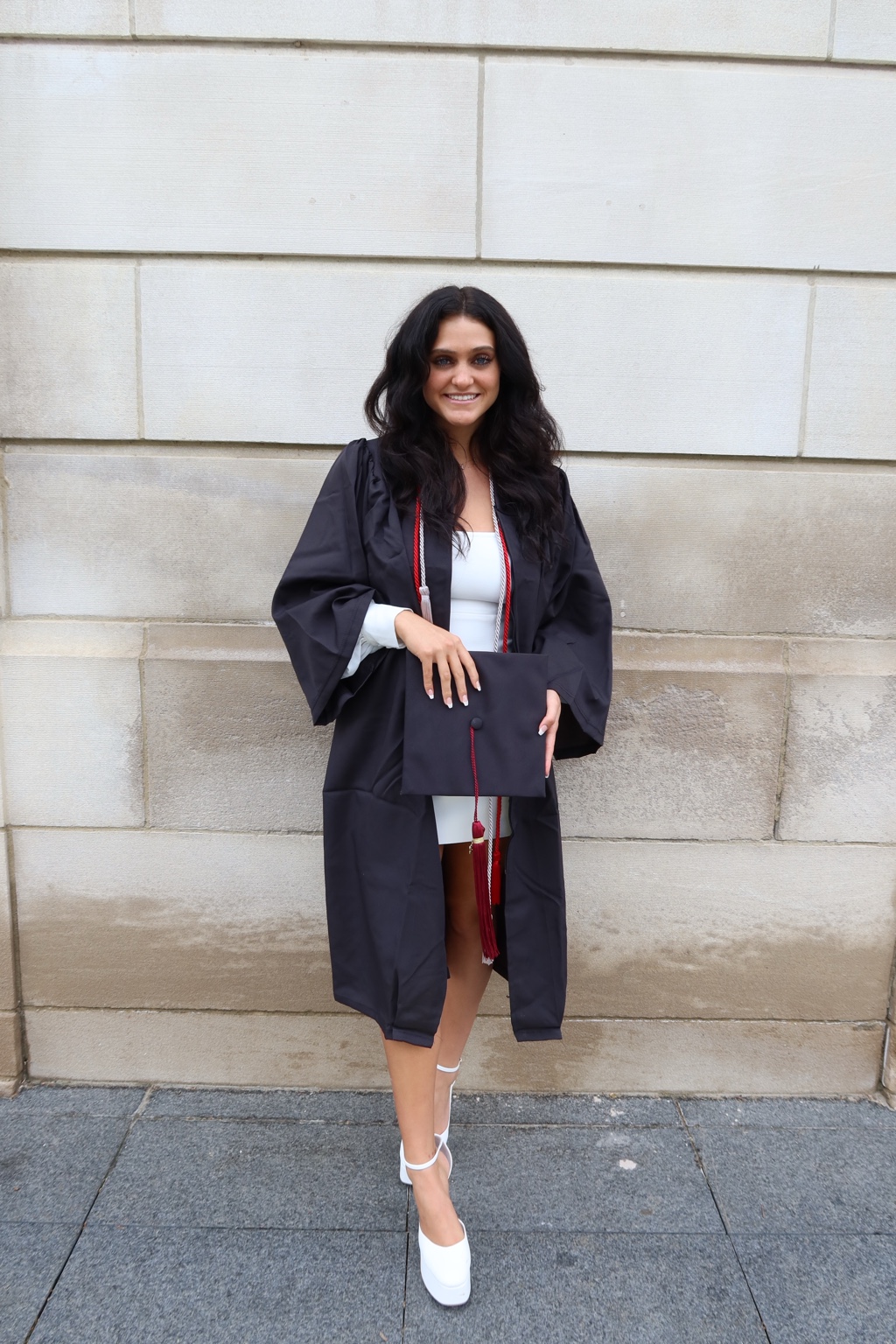 Lola DeJohn smiling in a graduation portrait