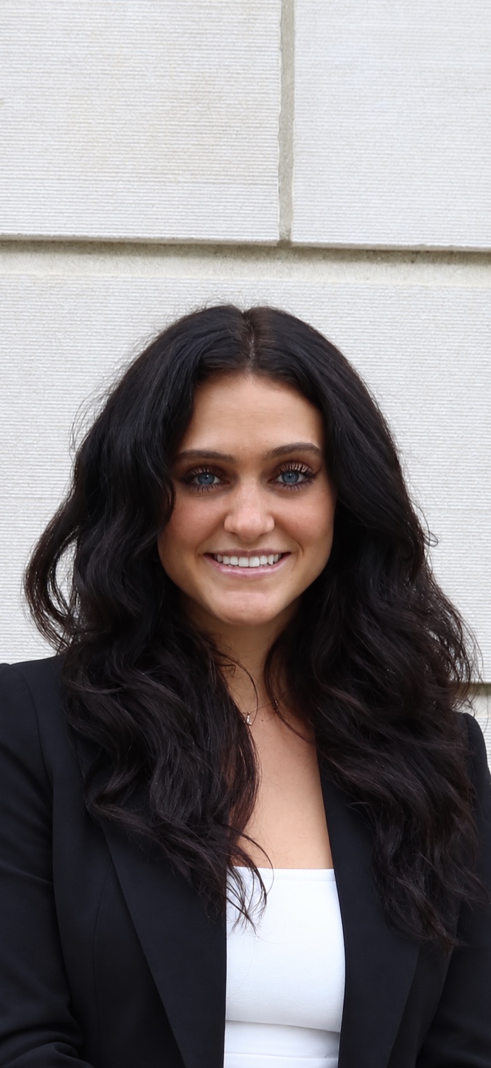 Lola DeJohn smiling in a black blazer